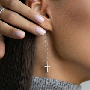 Detail of silver S925 cross drop earrings featuring sparkling cubic zirconia on long chain