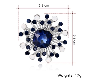 Detailed view of geometric silver brooch with blue crystals and white beads, 3.9cm x 3.9cm