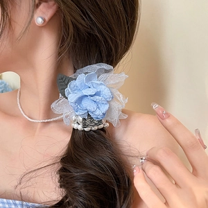 Detail of light blue fabric rose hair claw with white faux pearls on model's hair