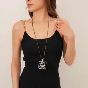 Détail d'un collier double couche avec pendentif géométrique mat noir et blanc élégant