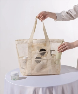Nahaufnahme der beigen Strandtasche aus Netzstoff mit vielen Taschen und Nylon-Struktur