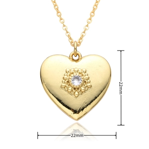 Detail view of 22mm gold heart pendant with floral pattern and cubic zirconia inlay