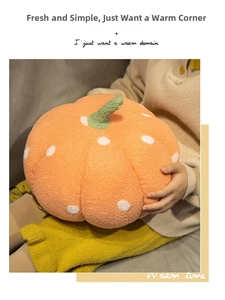 Detailed view of orange polka dot pumpkin pillow held by a person for cozy home decor