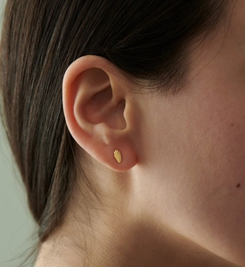 Macro shot of minimalist gold S925 silver stud earrings with delicate shell texture detail