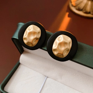 Macro shot of vintage round earrings with gold hammered metal in a green jewelry box