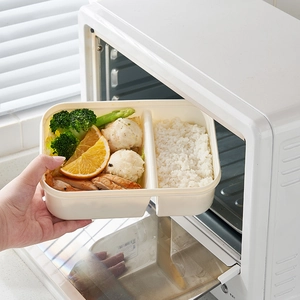 White divided lunch box with food being placed in a microwave for office and student use