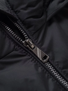 Detailansicht des robusten Metallreißverschlusses einer schwarzen winddichten Winterjacke