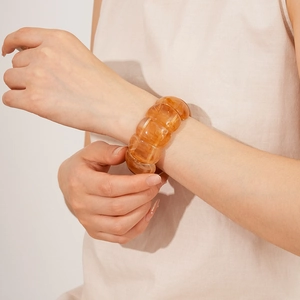 Close-up of amber acrylic chunky bracelet with polished geometric resin links on wrist