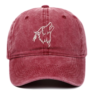 Close-up of white wolf head embroidery on a vintage washed red cotton baseball cap