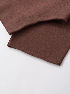 Detailed view of dark brown knitted hem showing high-quality metallic thread weave