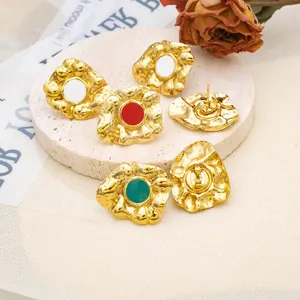 Retro hammered metal heart stud earrings with colorful enamel centers on stone tray