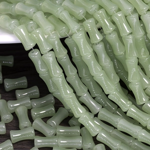 Detailed view of light green bamboo-shaped glass beads for DIY jewelry making