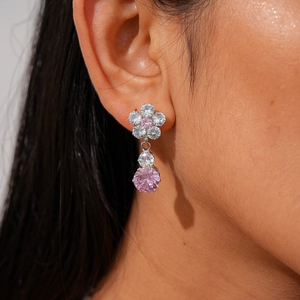 Detail of pink zircon flower earrings on model showing silver setting and craftsmanship