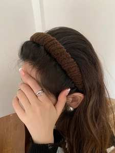 Close-up of a thick dark brown plush headband on a model for a stylish winter look