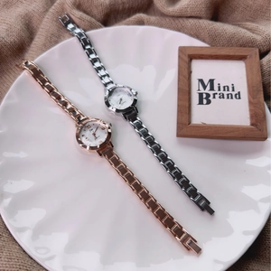 Detail of rose gold and silver small dial quartz watches on a decorative ceramic tray