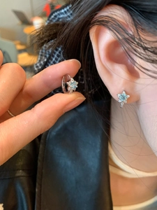 Vue rapprochée de boucles d'oreilles étoiles en argent avec zircon sur le lobe