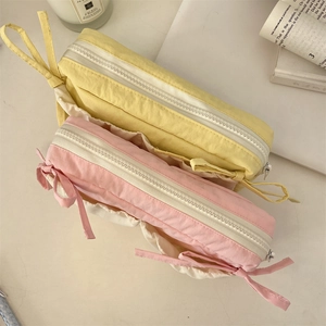 Detail of aesthetic bow pencil case with textured fabric and dual zipper storage design