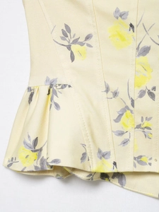 Detail of floral print poplin top with yellow blossoms and delicate ruffled hemline