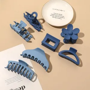 Collection of seven matte blue hair claws in various geometric and flower shapes