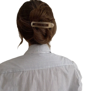 Minimalist matte transparent shark hair claw clip holding hair in a modern updo style