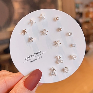 Set of 7 pairs of silver titanium steel earrings with star, pearl, and bow designs