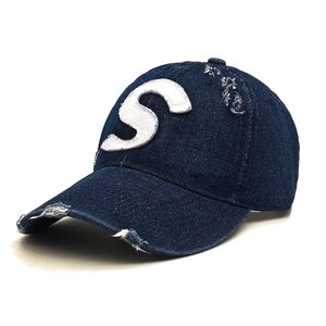 Distressed navy denim baseball cap with white S letter patch and vintage ripped details