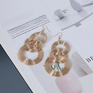 Chic gold geometric triple interlocking hoop dangle earrings on a lifestyle magazine