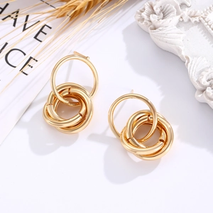Detail of twisted multi-hoop geometric gold earrings with textured metal finish