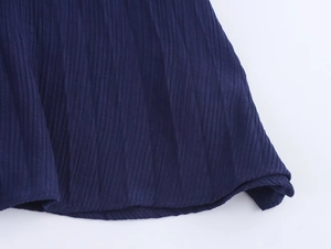 Detail des dunkelblauen ärmellosen Strickkleids mit feinen Falten und abgerundetem Saum