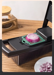 Macro shot of a 13-piece vegetable chopper with diced onions and green grid blades