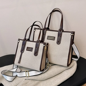 Contrast canvas tote bag with brown leather trim and striped shoulder strap in two sizes