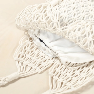 Detail of hollow woven cotton mesh bag with drawstring lining and copper buckle closure