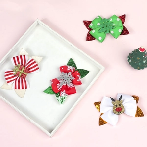 Detail of Christmas glitter bow hair clips featuring festive resin icons on a pink background