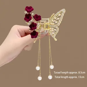 Detail of butterfly hair claw clip with burgundy velvet flowers and pearl tassels