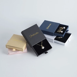 Detail of drawer-style jewelry gift boxes in multiple colors with ribbon handles