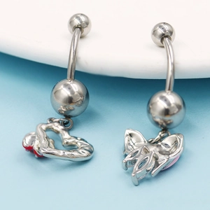 Détail macro du piercing de nombril argenté avec pendentifs cœur et papillon