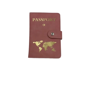 Close-up of pink PU leather passport holder with golden world map and secure snap closure