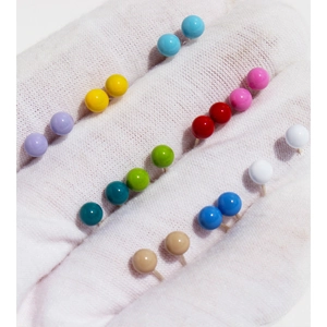 Colorful enamel candy stud earrings set held on a gloved hand for size comparison