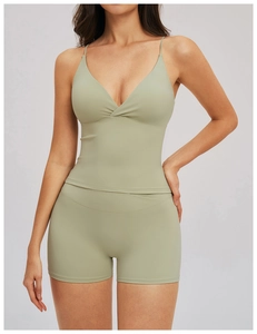 Détail du caraco de yoga vert sauge à fines bretelles et short de sport assorti