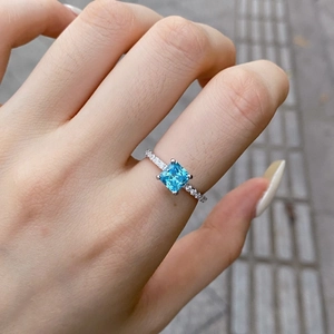 Close-up of S925 silver ring featuring a vibrant blue square-cut zircon stone on finger
