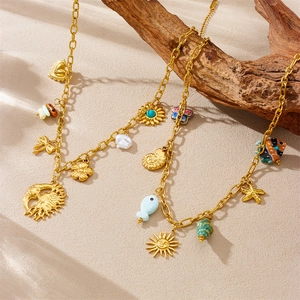 Detail of gold stainless steel necklaces with seashell and starfish charms on a branch