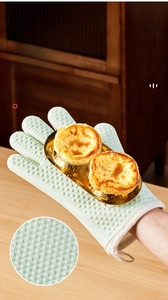 Close-up of mint green silicone oven glove with heart-shaped non-slip texture and loop