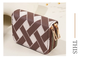 Close-up of dual gold zippers and textured lattice pattern on a compact wallet