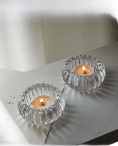 Détail des bougeoirs en verre strié avec bougies allumées pour une déco d'ambiance