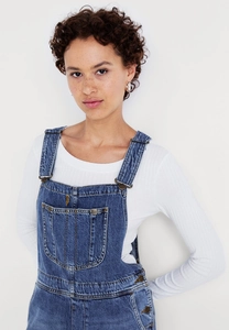 Detail of blue denim dungarees with silver metallic buckles and side button fasteners