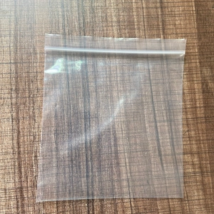 Macro detail of transparent PE zip-lock packaging bags on a natural wood surface
