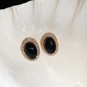 Vintage oval stud earrings with black gemstone and sparkling rhinestones in gold setting