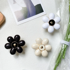 Minimalist flower phone socket stands in black white and yellow with golden heart center