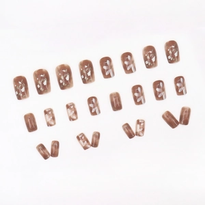Mocha floral press-on nails with white flower patterns and a glossy squoval shape finish