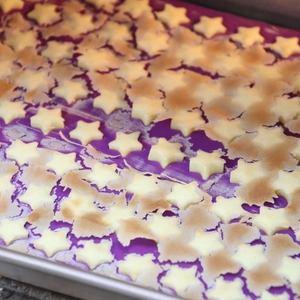 Purple silicone baking mat with star shapes for chocolate and cookies in a tray